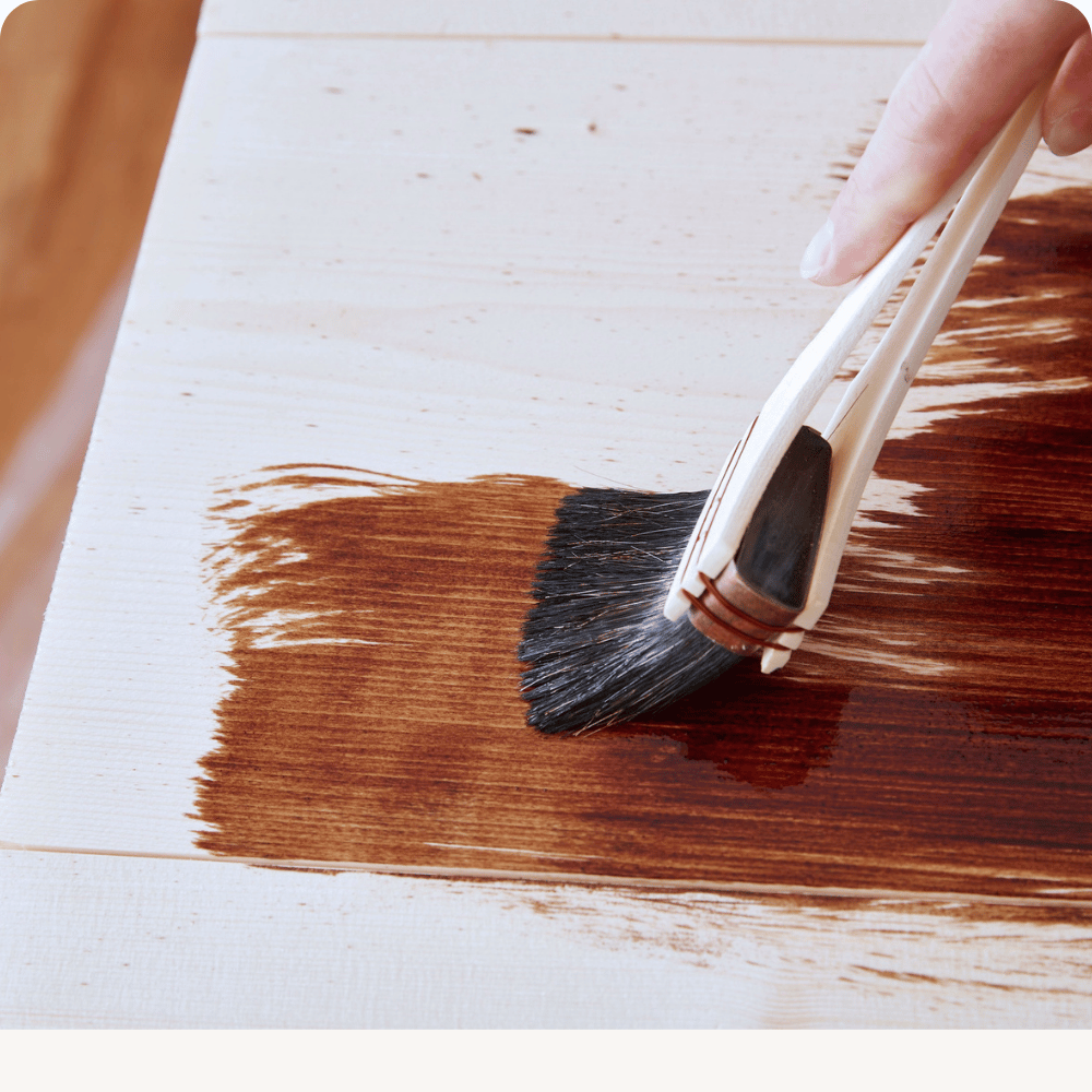 Wood stain being applied with a brush