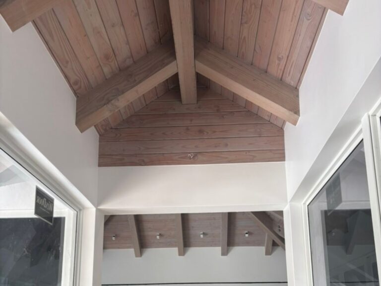 White-washed wood ceiling and exposed beams refinished by Nine Martin